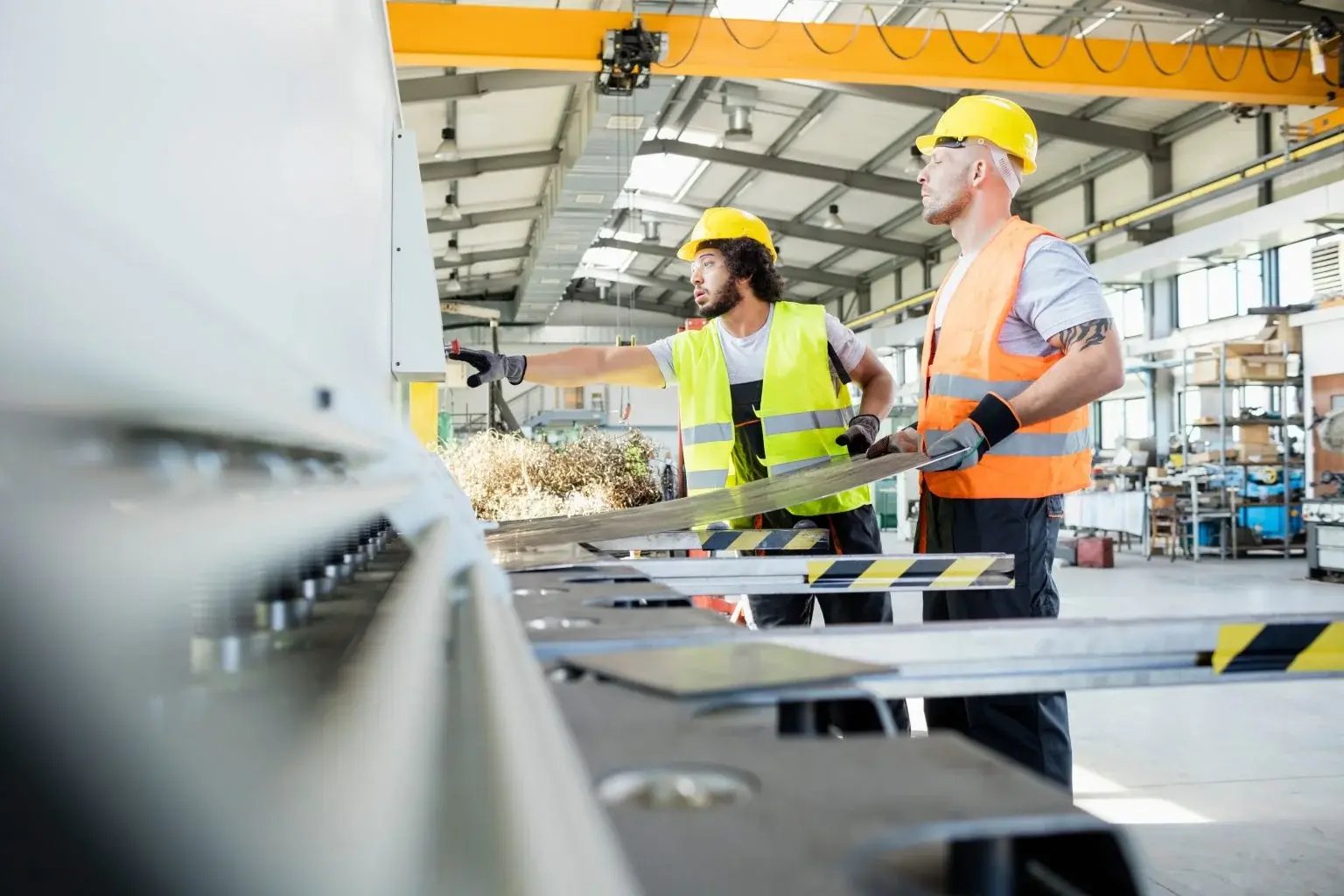 Workers using machinery in a manufacturing setting