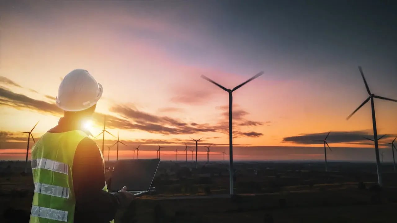 Worker next to wind farm
