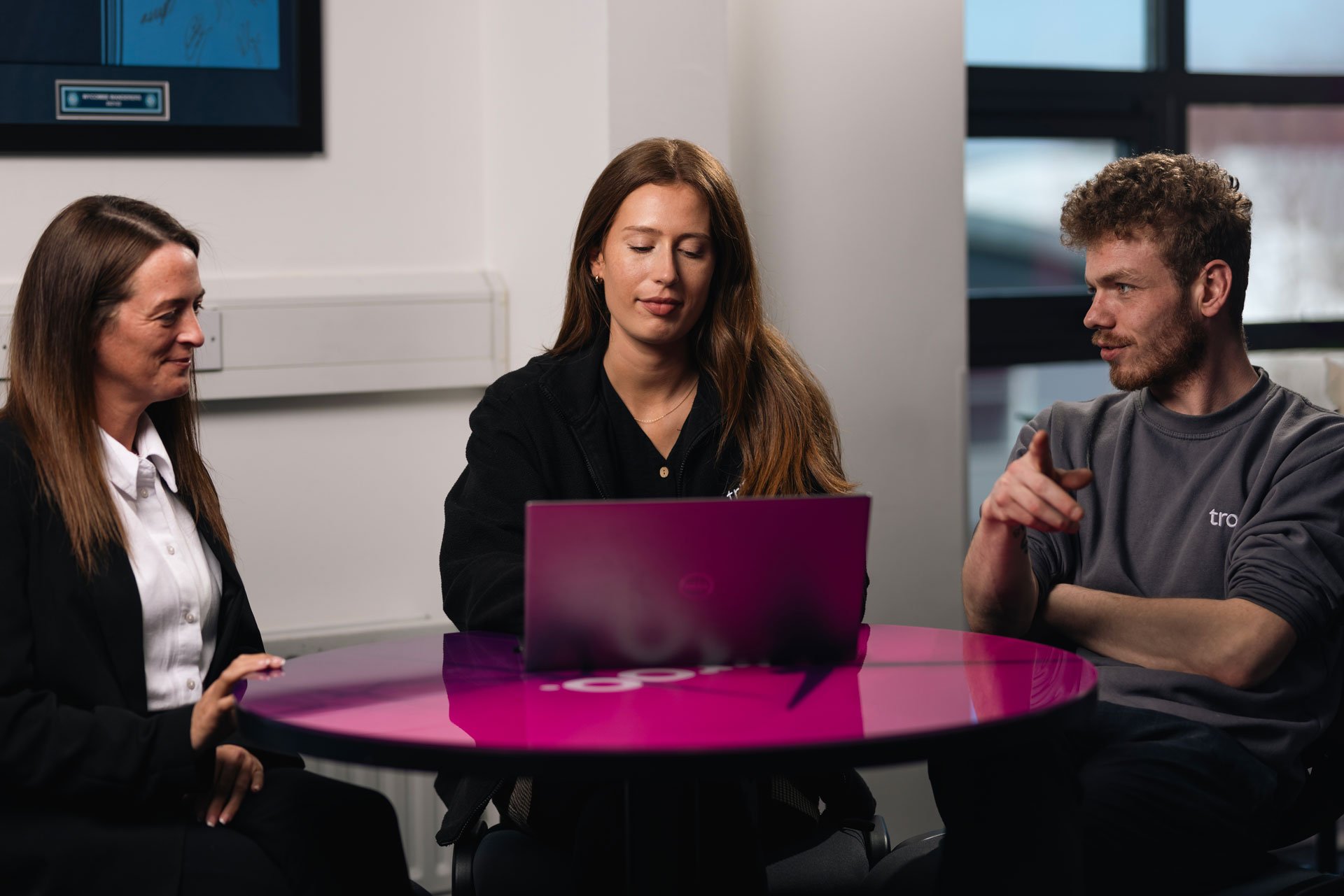 Meeting with 3 people looking over something on a laptop
