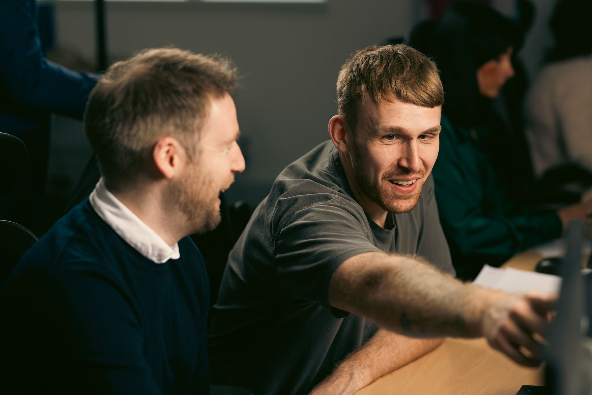Two people reviewing energy bills on a computer