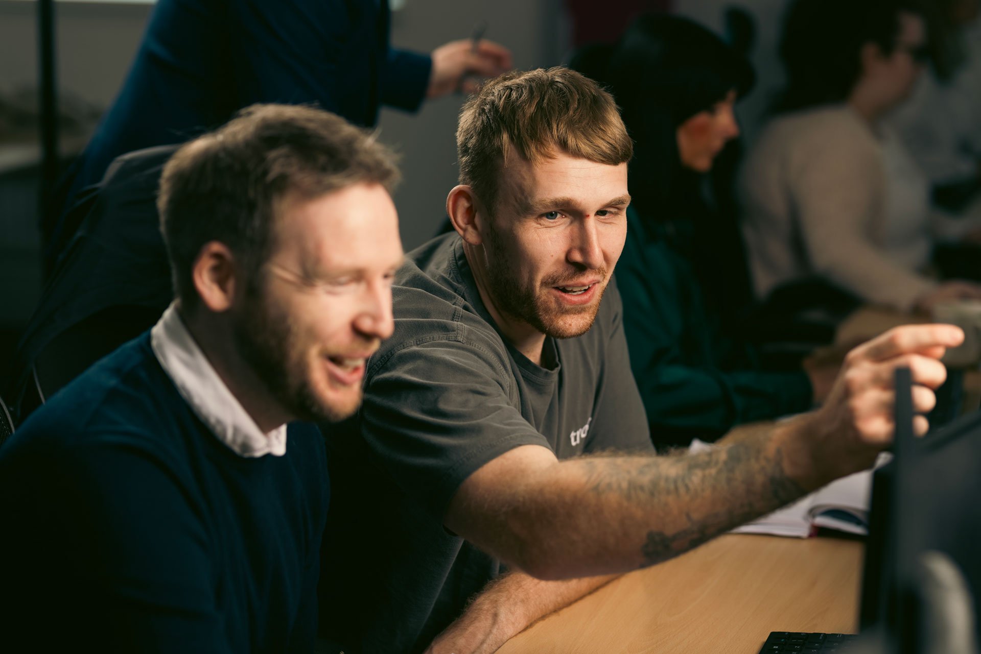 Two men smiling while having a conversation