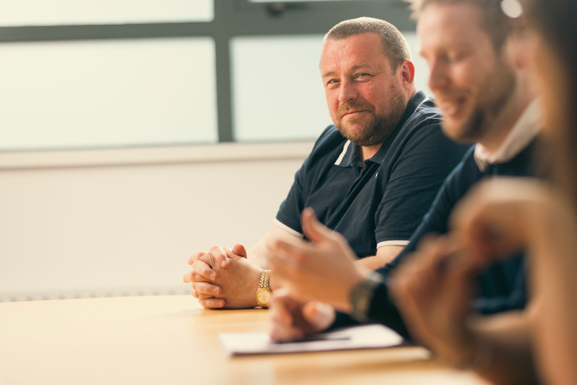 Two men sat around a meeting table in conversation