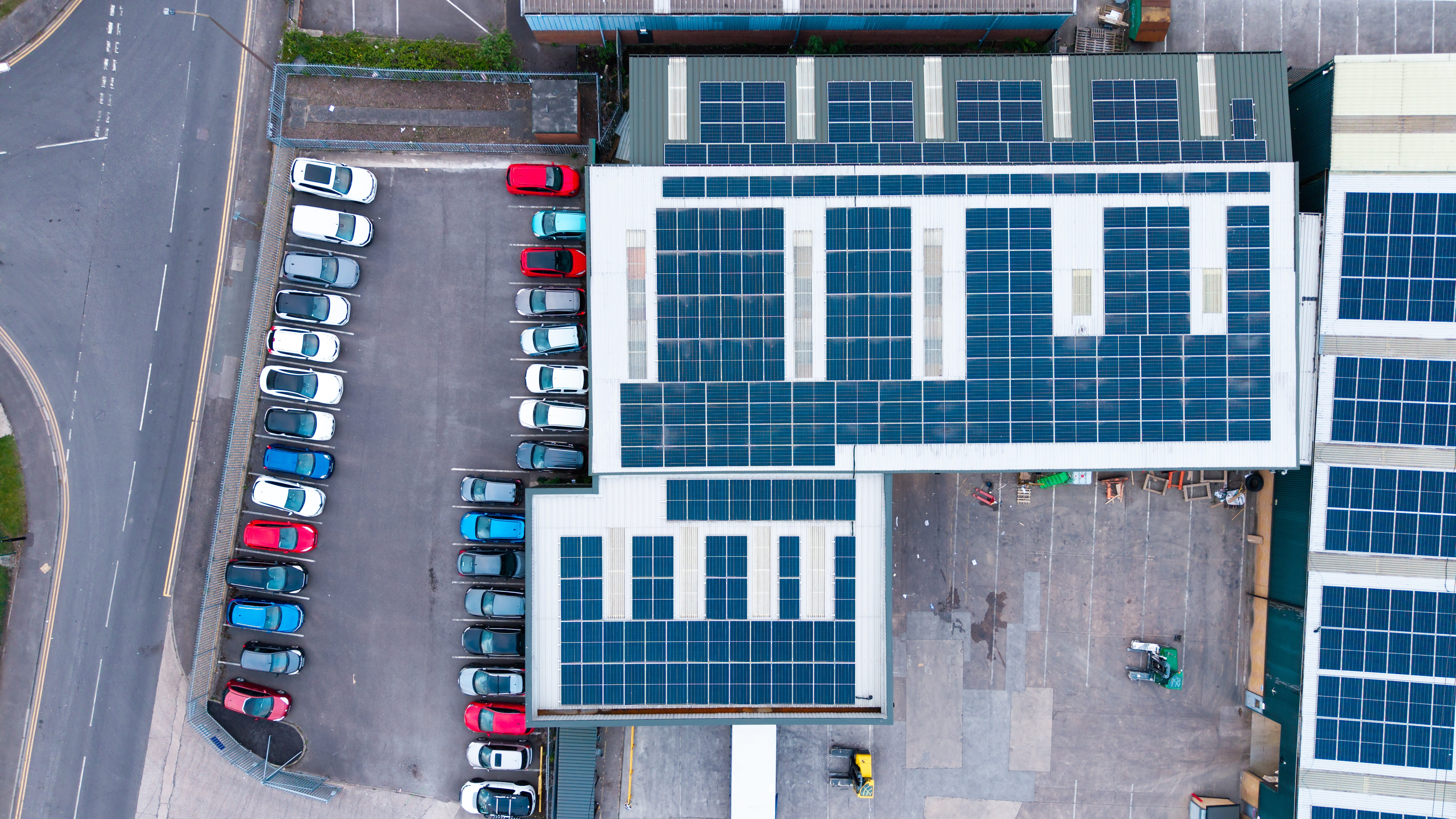 Aerial shot of a business with solar panels on the roof.
