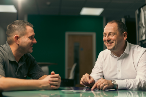 Two team members talking at a table about VAT charges
