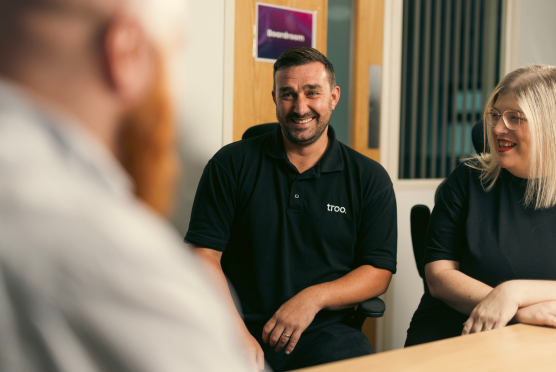 Conversation between three colleague around an office desk