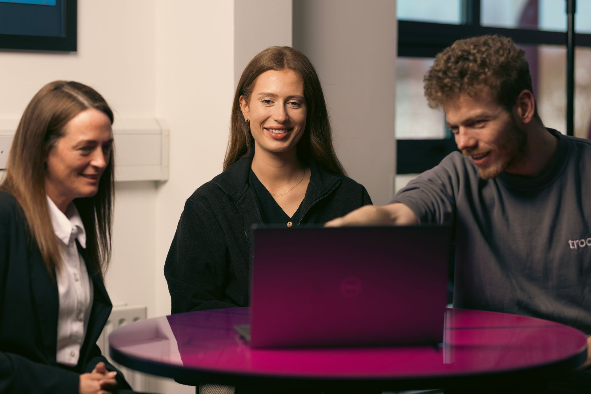 Three Troo Team members smiling during a meeting
