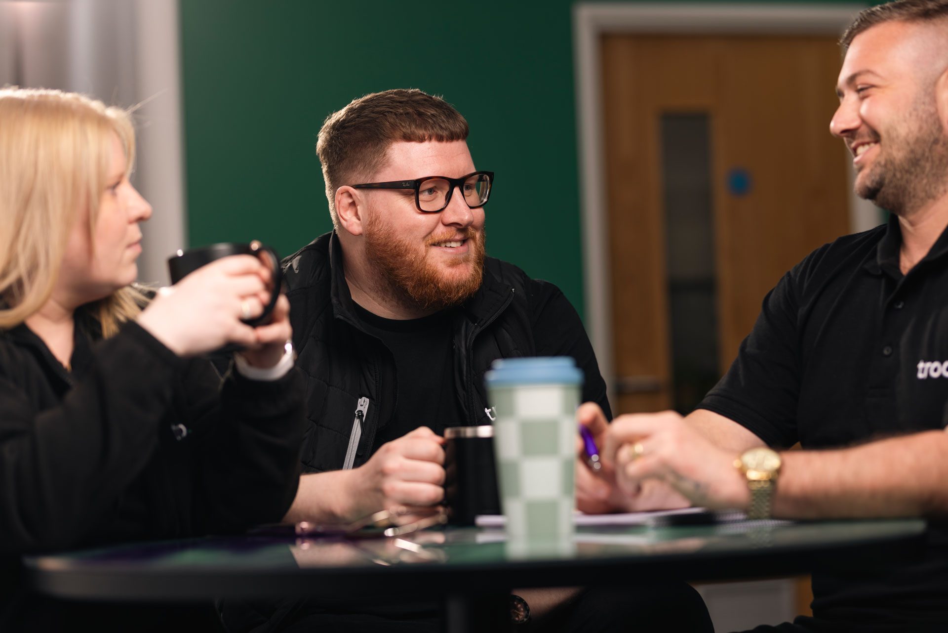 Three Troo Team members smiling during a meeting
